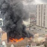 El video muestra el edificio envuelto en llamas, mientras columnas de humo negro llenan el aire.