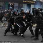 La mayor operación de seguridad en la historia reciente de Francia se desarrollará hoy para combatir a los alborotadores que quieren llevar 'fuego y sangre' a las calles, mientras continúan las protestas contra el aumento de las pensiones de Macron.  En la imagen: la policía antidisturbios detiene a un manifestante en París la semana pasada