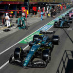 Aston Martin's Spanish driver Fernando Alonso and other drivers line up in the pit lane during a