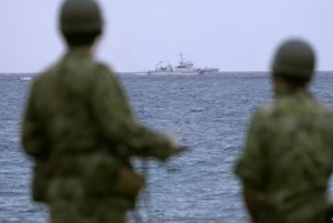 Miembros de la Fuerza Terrestre de Autodefensa de Japón observan cómo un barco de la Guardia Costera de Japón busca un helicóptero del ejército desaparecido en la isla de Miyako, prefectura de Okinawa, el 7 de abril de 2023. (AP)