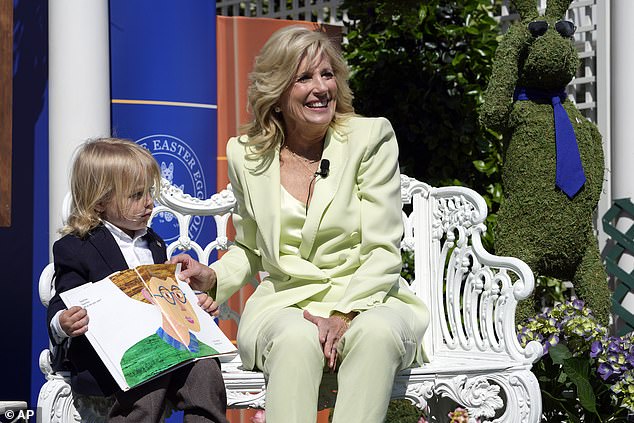 El bebé Beau Biden (izquierda), hijo de Hunter Biden, ayuda a su abuela, la primera dama Jill Biden (derecha) a leer el libro Oso pardo, oso pardo, ¿qué ves?  en el rollo de huevo de Pascua de la Casa Blanca del lunes