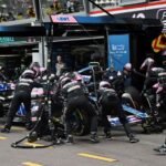 Team members change the wheels   of  Alpine's French driver Esteban Ocon in the pit lane the