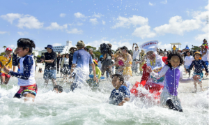 La gente juega en una playa en la ciudad de Shirahama, en la prefectura de Wakayama, en el oeste de Japón, el 3 de mayo de 2023. La popular playa para nadar, conocida por su arena blanca, abre el mismo día, la primera entre las playas de la isla principal japonesa de Honshu. .  (Kiodo)