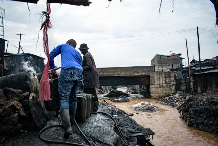 Producers of chang’aa, the local brewed alcohol, use oil drums to cook at an illegal distillery in the informal settlement of Mathare in Nairobi on 26 April 2023.
