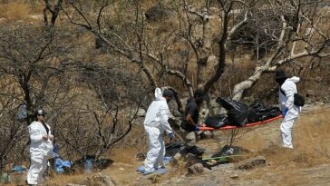 Peritos forenses trabajan este martes en el traslado de varias bolsas con restos humanos extraídos del fondo de un barranco en el occidental estado mexicano de Jalisco.