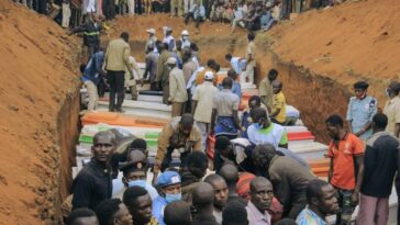 Civilians and Red Cross volunteers attend the burial of 62 displaced people who were massacred in the Plaine Savo IDP camp near Bule in Ituri province, north-eastern Democratic Republic of Congo.