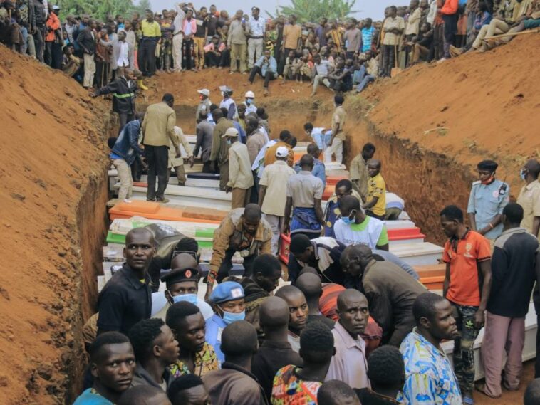 Civilians and Red Cross volunteers attend the burial of 62 displaced people who were massacred in the Plaine Savo IDP camp near Bule in Ituri province, north-eastern Democratic Republic of Congo.