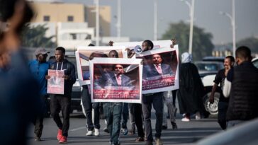 Protesters hold up posters denouncing the former President of Mauritania, Mohamed Ould Abdel Aziz ahead of his trial in Nouakchott in January 2023. (Photo by Med LEMIN RAJEL / AFP)