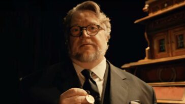 Guillermo del Toro holding a key in front of the cabinet in Guillermo del Toro