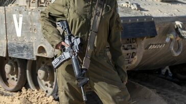 Tamara, de 20 años, sosteniendo un rifle en un lugar clasificado en el sur de Israel, cerca de la frontera con Egipto.