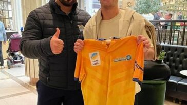 El presidente de la Federación Ucraniana de Rugby, Artur Martyrosia, con Cleary y una camiseta de Ucrania.