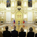 Se podía ver a Putin hablando con confianza mientras se encontraba a una distancia incómoda de los embajadores frente a una enorme puerta dorada con banderas a cada lado.