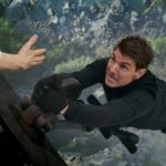 Ethan Hunt (Tom Cruise) hanging off a train in Mission: Impossible - Dead Reckoning Part 1