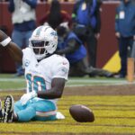 Miami Dolphins wide receiver Tyreek Hill (10) celebrates in the end zone after catching a touchdown pass against the Washington Commanders during the first quarter at FedExField.