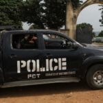 A police truck is stationed outside the University of Abuja Staff Quarters gate in Abuja, Nigeria where unknown gunmen had previously kidnapped several people.