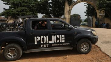 A police truck is stationed outside the University of Abuja Staff Quarters gate in Abuja, Nigeria where unknown gunmen had previously kidnapped several people.