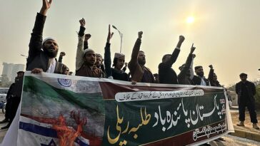 Activistas paquistaníes de la musulmana Talba Mahaz sostienen una pancarta que dice en urdu