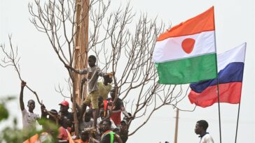 Niger and Russia flags fly together as supporters of Niger's National Council of Safeguard of the Homeland (CNSP) protest outside the Niger and French airbase in Niamey in September 2023 to demand the departure of the French army. (Photo by AFP)
