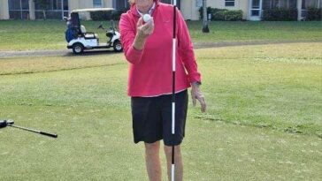 Mary Gale poses with her ball she used to record an ace on the 14th hole. It was her second hole-in-one of her round.