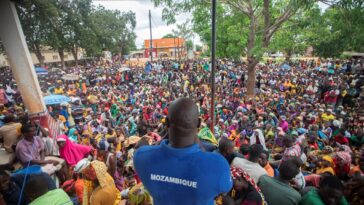 A staff member of the World Food Program addresses displaced people from the province of Cabo Delgado gathering to received humanitarian aid in the town of Namapa, Mozambique on 27 February 2024 following an outbreak of violence. 
