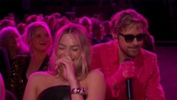 Margot Robbie laughing while Ryan Gosling performs "I