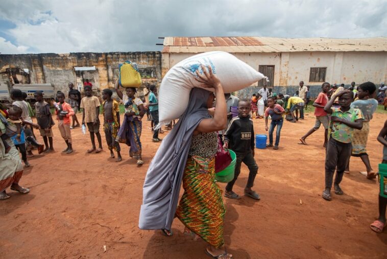 A woman carries a bag of food distributed by the World Food Program (WFP) to displaced people from the province of Cabo Delgado, at the 21 de Abril Tribune School in the town of Namapa, Erati district of Nampula, Mozambique. (Alfredo Zuniga/ AFP)