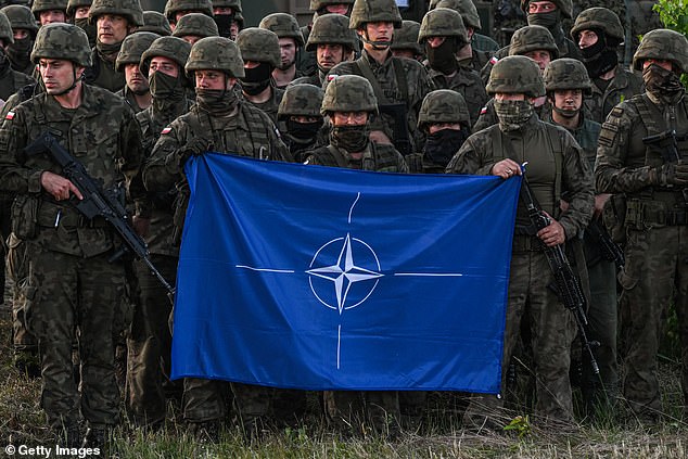 Soldados polacos sostienen la bandera de la OTAN después de un ejercicio de entrenamiento multinacional en Polonia en 2022.