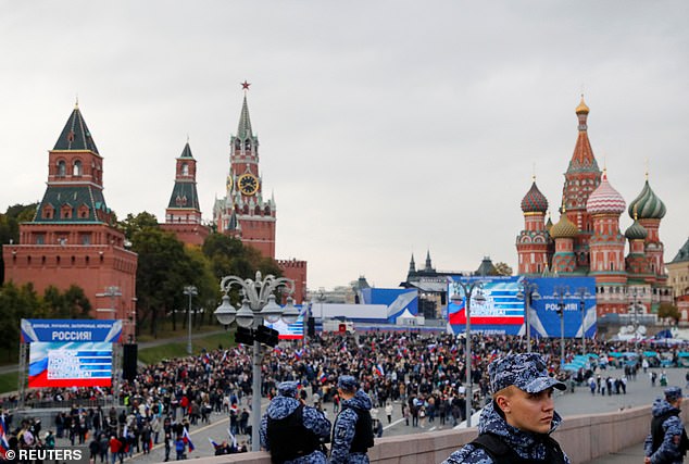 Agentes encargados de hacer cumplir la ley hacen guardia mientras la gente camina hacia la Plaza Roja para asistir a eventos que marcan la anexión de los territorios de Ucrania controlados por Rusia, 30 de septiembre de 2022.