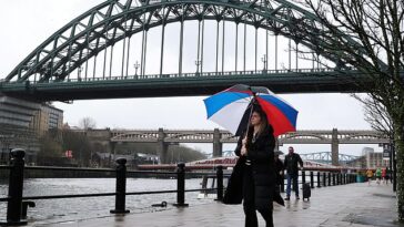 El clima frío, húmedo y ventoso azotará hoy partes del Reino Unido.  En la imagen: una mujer sosteniendo un paraguas en el muelle de Newcastle esta mañana.
