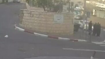 En las imágenes se puede ver un coche blanco acelerando una carretera en Jerusalén mientras tres judíos se paran a un lado de la carretera y conversan.