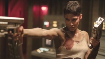 A banged up Sofia Boutella aiming her guns in Rebel Moon - Part Two: The Scargiver.