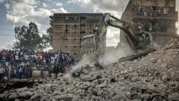 Bystanders follow rescue operations in front of a collapsed building that was under demolition in the Mathare informal settlement of Nairobi, on 14 May. (Luis Tato/AFP)