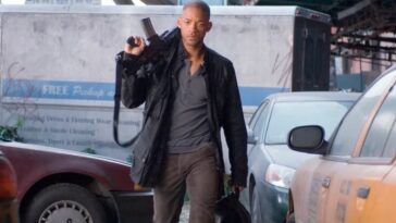 Will Smith armed and walking through parked cars in I Am Legend.