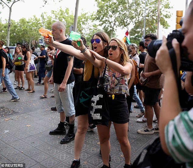 Los manifestantes disparan agua con pistolas de agua a los turistas durante una protesta contra el turismo de masas en Barcelona, ​​España, el 6 de julio de 2024