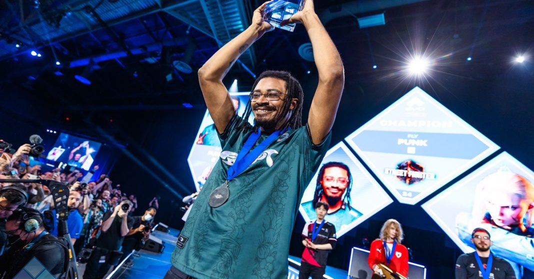 Photo from Evo 2024 featuring Victor “Punk” Woodley holding up his trophy for Street Fighter 6.