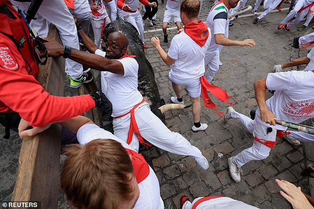 Los juerguistas corren durante el encierro de toros en el festival de San Fermín en Pamplona, ​​España, el martes