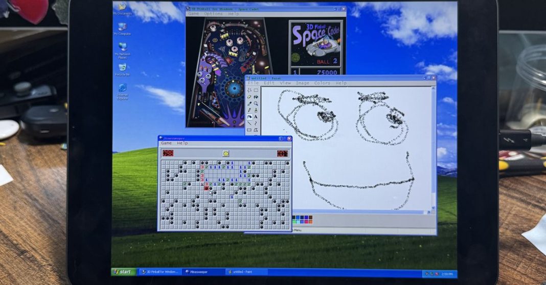 A picture of an iPad running Windows XP, with Minesweeper, 3D Pinball, and MS Paint on the screen.