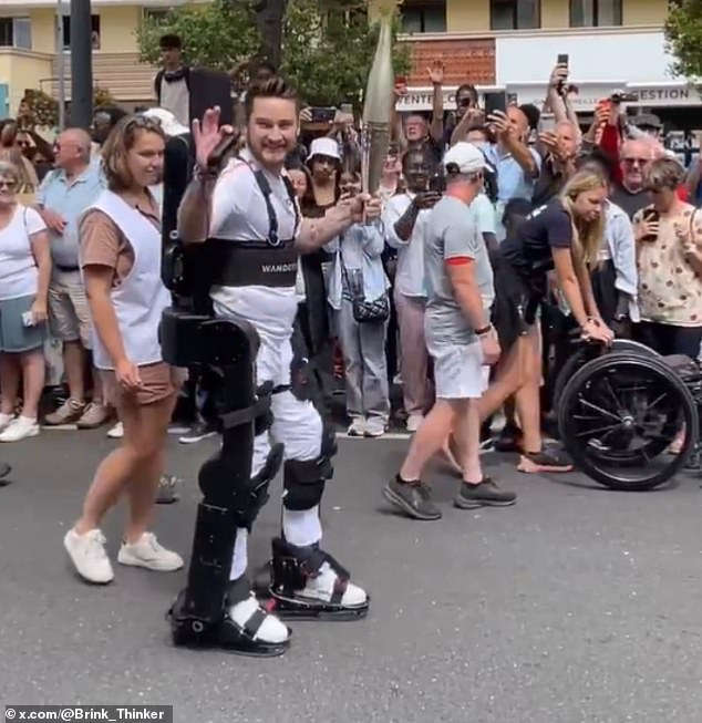 Kevin Piette, de 36 años, que perdió el uso de sus piernas en un accidente a los 11 años, es captado caminando por las calles de París sosteniendo la antorcha olímpica.