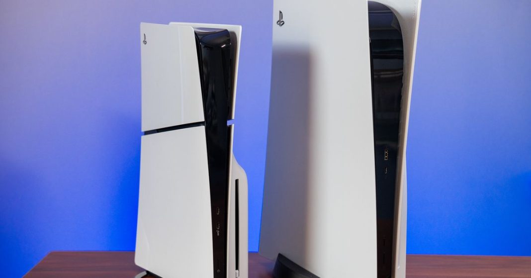 The new PlayStation 5 slim and standard PlayStation 5 standing vertically side by side on a table.