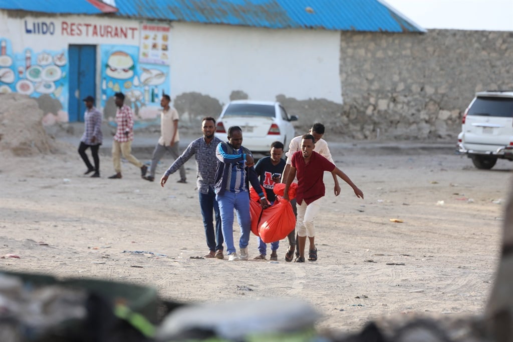 Relatives carry the body of a woman killed during an attack in Mogadishu on August 3, 2024.