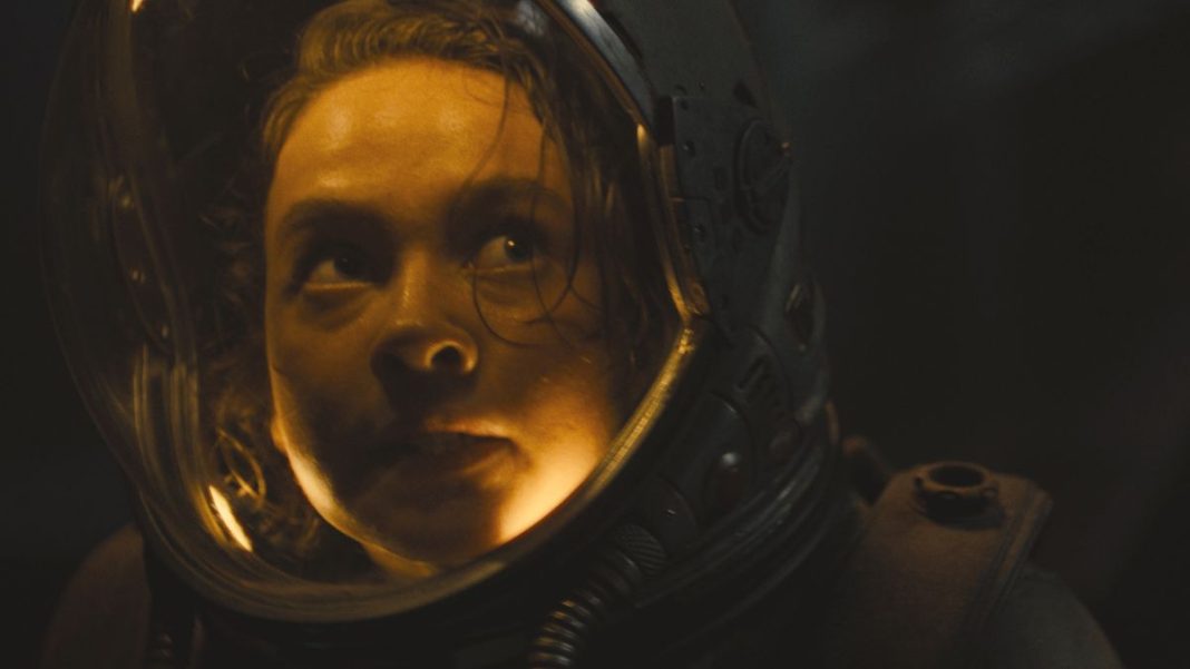 Cailee Spaeny looks up in horror while wearing a space suit in Alien: Romulus.