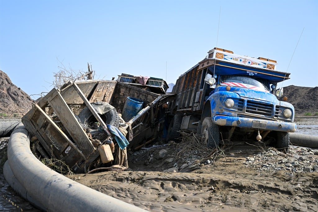 Damaged trucks buried in mud after the collapse of the Arbaat Dam, 40km north of Port Sudan, on 25 August 2024. (AFP)