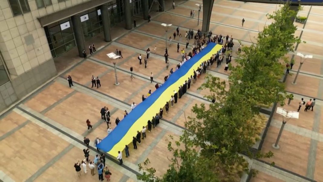 En Bruselas se despliega una enorme bandera ucraniana en vísperas del Día de la Independencia
