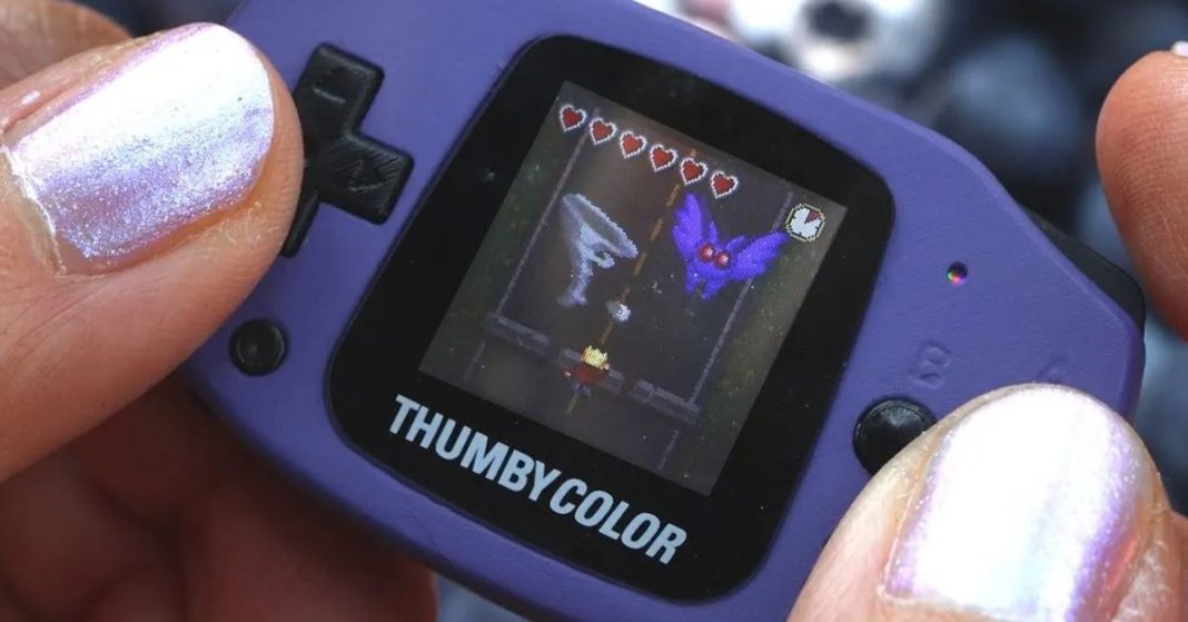 A gamer playing the Thumby Color GBA clone.