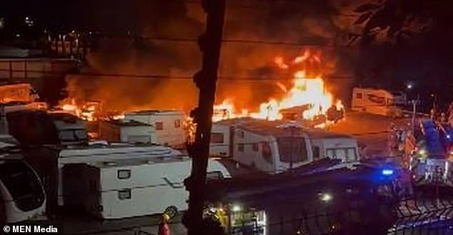 Los bomberos están combatiendo esta noche un gran incendio en un depósito de caravanas en Oldham, que al parecer se puede ver a kilómetros de distancia.