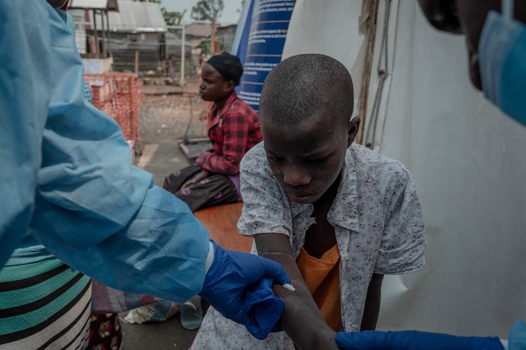 Doctors take samples from a patient at the mpox treatment centre in Nyiragongo general referral hospital, north of Goma in the Democratic Republic of Congo, on 16 August 2024. (Guerchom Ndebo/ AFP)