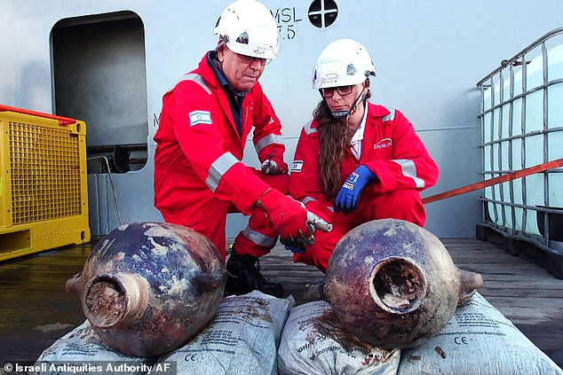 El barco de 40 pies, encontrado a una milla de profundidad en el fondo marino a 56 millas de la costa de Israel, data de hace 3.300 años, de finales de la Edad de Bronce, dicen los expertos. Aquí, los investigadores revisan las jarras que fueron descubiertas en el pecio, a más de una milla de profundidad en el lecho del Mediterráneo.