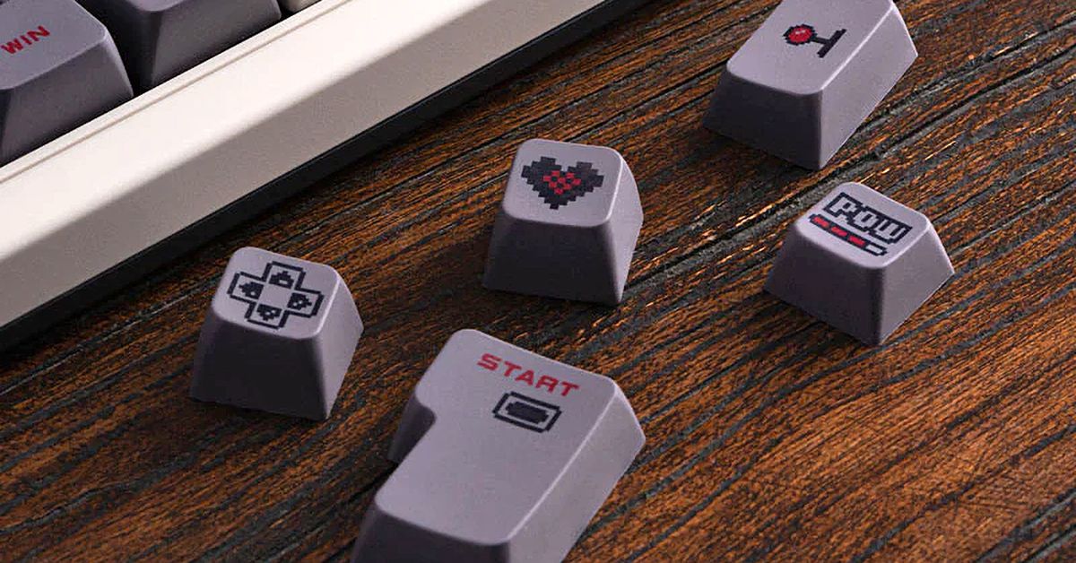 Several keycaps sitting next to 8BitDo’s Retro Mechanical Keyboard.