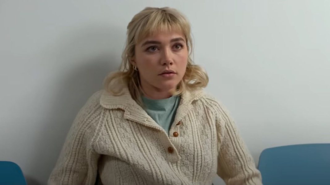 Florence Pugh sitting up and looking forward in We Live In Time.