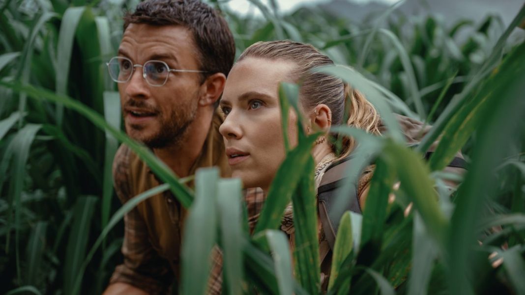 Jonathan Bailey and Scarlett Johansson looking up in awe from long grass in Jurassic World Rebirth.